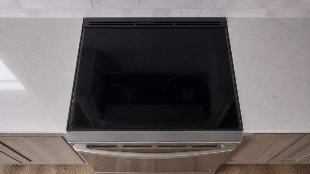 A slide-in electric range with a smooth radiant top and the downdraft vent lowered flush behind it, seen straight down from above.