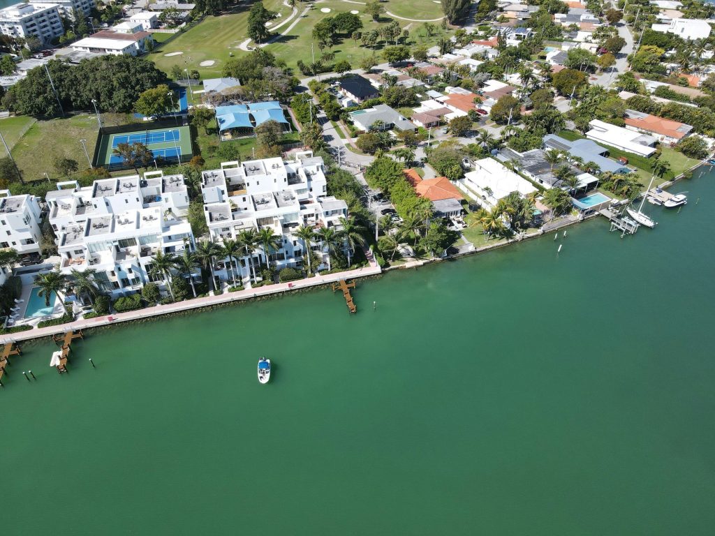 White waterfront townhouses and low houses along a South Florida bay, seen from the air